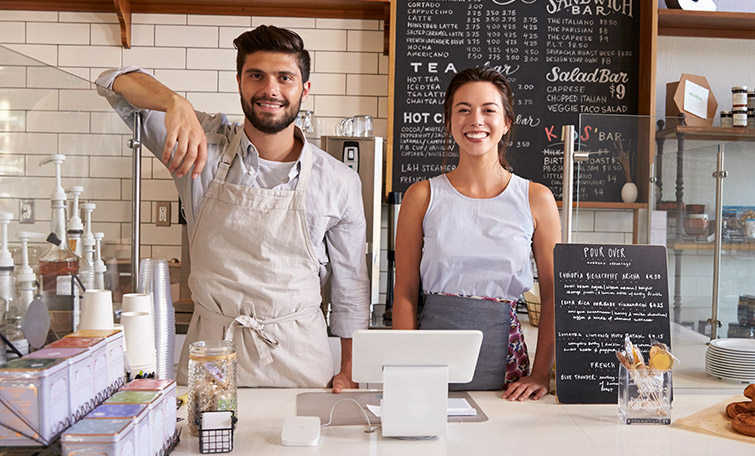 Man and woman standing behind cafe counter