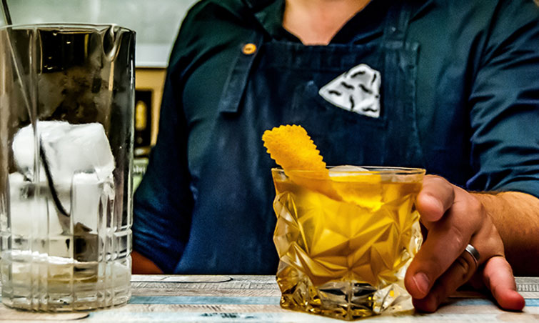 Yellow cocktail with lemon rind