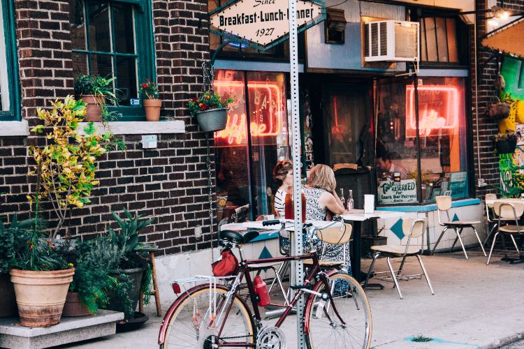 Bicycle sits outside a busy cafe.