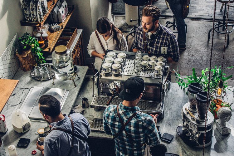 Baristas make and serve coffee in a cafe.